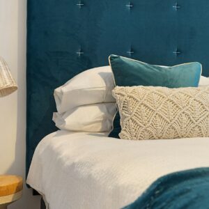 cama azul e colchão com travesseiros