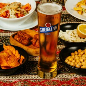 uma mesa cheia de comida industrializada e um copo de chopp