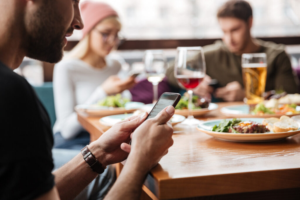pessoas usando smartphone no restaurante