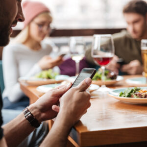 pessoas usando smartphone no restaurante