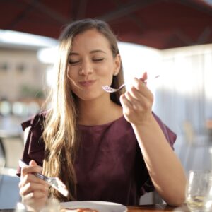mulher comendo e sorrindo