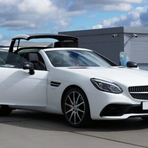 Elegant white Mercedes Benz convertible captured outdoors, showcasing luxury and style.