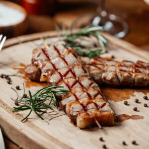 cortes de carne grelhada sobre uma tábua de madeira