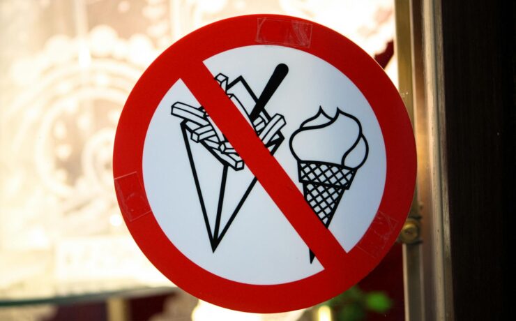 A sign in Brussels shows a prohibition on ice cream and fries in a restaurant setting.