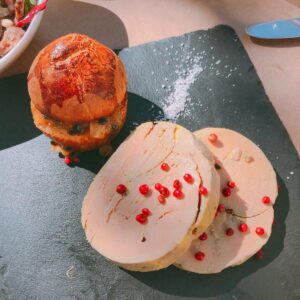 From above of delicious cut meatloaf served on black slate plate with appetizing crispy burger and decorated with pomegranate seeds