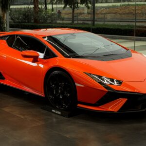 a bright orange sports car parked in a garage