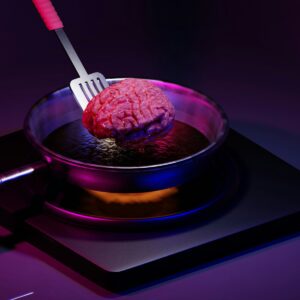 a pink brain in a bowl with a fork in it