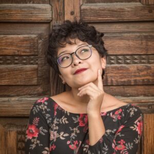 woman leaning against door while holding her cheek