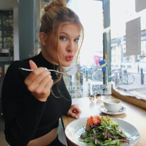 woman in black long sleeve shirt eating