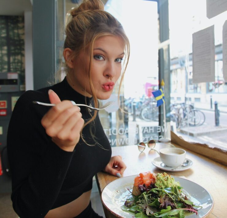 woman in black long sleeve shirt eating