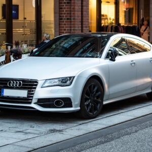 silver Audi sedan parked on street beside restore