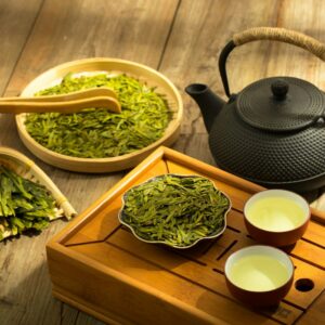 a tea set with a teapot and two cups of green tea