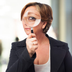 Mulher olhando para a câmera com uma grande lupa