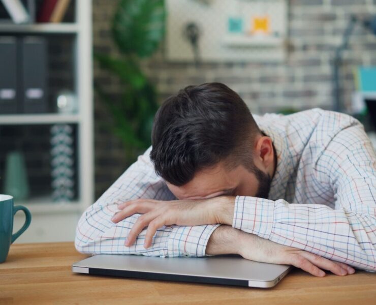 homem debruçado sobre uma mesa, cansaço, estudar,