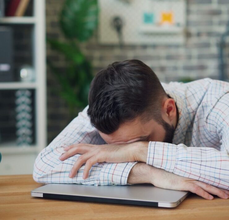 homem debruçado sobre uma mesa, cansaço, estudar,